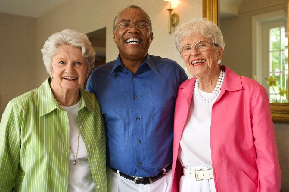 three smiling older adults